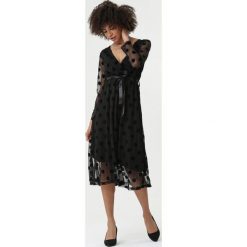 Czarna Sukienka Fairbanks. Czarne sukienki damskie Born2be, na imprezę, s, bez wzorów, z dzianiny, eleganckie, bez kołnierzyka, bez rękawów, kopertowe. Za 119,99 zł.