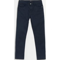 Bawełniane spodnie slim fit - Granatowy. Niebieskie spodnie męskie Reserved, bez wzorów, z bawełny. Za 89,99 zł.