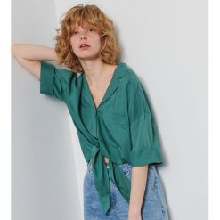 Koszula oversize z wiązaniem - Turkusowy. Niebieskie koszule damskie Reserved, bez wzorów, bez kołnierzyka, bez rękawów. W wyprzedaży za 29,99 zł.