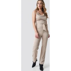 Hannalicious x NA-KD Satynowy kombinezon - Beige. Brązowe kombinezony damskie marki Hannalicious x NA-KD, z poliesteru, z dekoltem na plecach. W wyprzedaży za 97,18 zł.