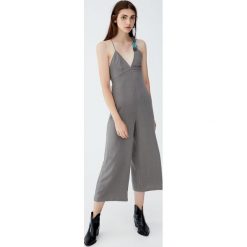 Długi kombinezon z ramiączkami skrzyżowanymi na plecach. Szare kombinezony damskie marki Pull&Bear, bez wzorów, z dekoltem na plecach, z długim rękawem, długie. Za 96,90 zł.
