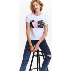 T-shirt damski z ciekawą aplikacją w kwiaty wiązaną z tyłu. Białe t-shirty damskie TROLL, m, z aplikacjami, eleganckie. Za 39,99 zł.