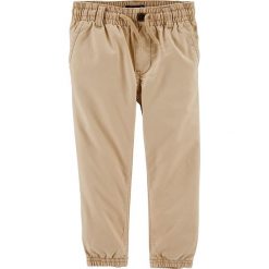 Spodnie w kolorze beżowym. Brązowe spodnie niemowlęce OshKosh, w paski, z bawełny. W wyprzedaży za 49,95 zł.