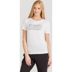 T-SHIRT GLITTER TEE Guess. Białe t-shirty damskie Guess, s, z nadrukiem, z bawełny, z okrągłym kołnierzem. Za 94,50 zł.