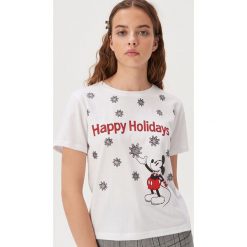Koszulka z zimowym nadrukiem Disney - Biały. Białe koszulki damskie Sinsay, s, z nadrukiem, bez kołnierzyka, bez rękawów. W wyprzedaży za 9,99 zł.