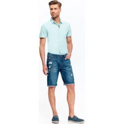 SZORTY MĘSKIE JEANSOWE Z PRZESZYCIAMI. Niebieskie szorty męskie marki Top Secret, na lato, m, z jeansu, krótkie. W wyprzedaży za 39,99 zł.