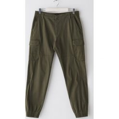 Bawełniane joggery cargo - Zielony. Zielone spodnie męskie Sinsay, bez wzorów, z bawełny. Za 79,99 zł.