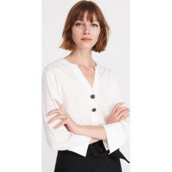 Bluzka z ozdobnymi guzikami - Kremowy. Białe bluzki damskie Reserved, bez wzorów, bez kołnierzyka, bez rękawów. W wyprzedaży za 29,99 zł.
