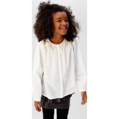 Mango Kids - Koszula dziecięca Ivone 110-164 cm. Białe bluzki dziewczęce Mango Kids, bez wzorów, z bawełny, z okrągłym kołnierzem, z długim rękawem, długie, bez kaptura. Za 89,90 zł.