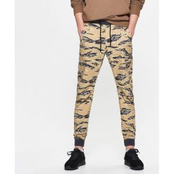 Dresowe joggery camo - Żółty. Żółte bez kategorii marki Cropp, z dresówki. W wyprzedaży za 39,99 zł.