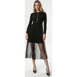 Czarna Sukienka Heila. Czarne sukienki damskie Born2be, s, bez wzorów, z dzianiny, eleganckie, z okrągłym kołnierzem, z długim rękawem, długie, midi, rozkloszowane. Za 149,99 zł.