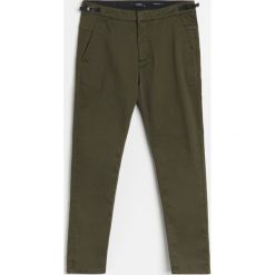 Chinosy slim z regulacją w pasie - Khaki. Brązowe spodnie męskie Reserved, bez wzorów. Za 129,99 zł.