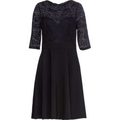Sukienka bonprix czarny. Czarne sukienki damskie bonprix, w koronkowe wzory, z koronki, eleganckie, bez kołnierzyka, bez rękawów, rozkloszowane. Za 139,99 zł.