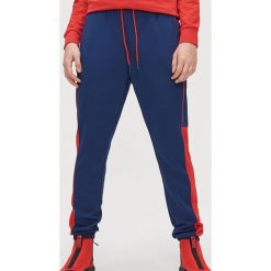 Dresowe joggery z lamówką - Granatowy. Niebieskie spodnie męskie Cropp, s, bez wzorów, z dresówki. Za 99,99 zł.