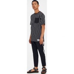 Koszulka w pionowe paski z gładką kieszonką. Czarne koszulki męskie marki Pull&Bear, m, w paski, bez kołnierzyka, z krótkim rękawem, krótkie. Za 49,90 zł.