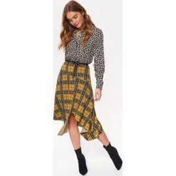 Dzianinowa spódnica w kratę, w modnym fasonie. Czarne spódniczki damskie Top Secret, na co dzień, na zimę, bez wzorów, z dzianiny, eleganckie, midi, asymetryczne. W wyprzedaży za 49,99 zł.