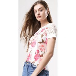 Biała Bluzka Harmonize. Białe bluzki damskie marki Born2be, s, z aplikacjami, z koronki, z okrągłym kołnierzem, z krótkim rękawem. Za 19,99 zł.