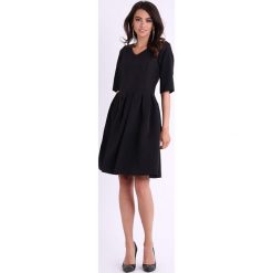 Sukienka w kolorze czarnym. Czarne sukienki damskie Jesienny butik, xs, bez wzorów, z dekoltem na plecach, bez rękawów, midi, rozkloszowane. W wyprzedaży za 119,95 zł.