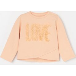 Bawełniana bluza z aplikacją - Kremowy. Białe bluzy damskie Reserved, z aplikacjami, z bawełny, bez rękawów, bez kaptura. Za 55,99 zł.