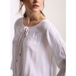 Bluzka długi rękaw luźna. Białe bluzki damskie Top Secret, z haftami, eleganckie, bez kołnierzyka, z długim rękawem. W wyprzedaży za 39,99 zł.