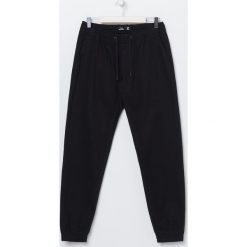 Joggery z tkaniny - Czarny. Czarne spodnie męskie Sinsay, bez wzorów, z tkaniny. Za 49,99 zł.