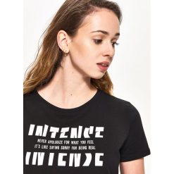 T-shirt z napisem - Czarny. Czarne t-shirty damskie Sinsay, s, z napisami, bez kołnierzyka. W wyprzedaży za 7,99 zł.