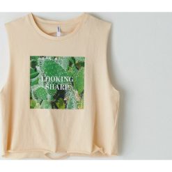 Top z nadrukiem - Kremowy. Białe topy damskie Cropp, s, z nadrukiem, bez kołnierzyka. W wyprzedaży za 19,99 zł.