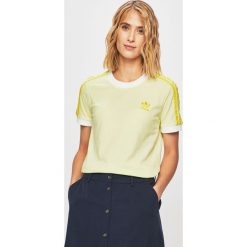 Adidas Originals - T-shirt. Żółte topy damskie adidas Originals, bez wzorów, z bawełny, z okrągłym kołnierzem. W wyprzedaży za 114,90 zł.