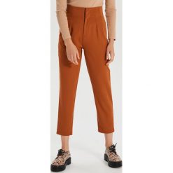 Materiałowe spodnie high waist - Brązowy. Pomarańczowe spodnie damskie Cropp, bez wzorów, z tkaniny, z podwyższonym stanem. Za 79,99 zł.