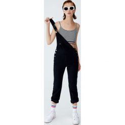 Krótki top z kolorowym pasem. Czarne topy damskie marki Pull&Bear, w kolorowe wzory. Za 29,90 zł.