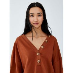 Bawełniana bluza z guzikami. Pomarańczowe bluzy damskie Pull&Bear, bez wzorów, z bawełny, bez rękawów, bez kaptura. Za 99,90 zł.