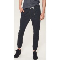 Materiałowe joggery - Granatowy. Niebieskie spodnie męskie marki House, s, bez wzorów, z tkaniny. Za 99,99 zł.