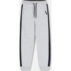 Joggery z kontrastowymi lampasami -. Spodnie męskie Reserved, bez wzorów. Za 45,99 zł.