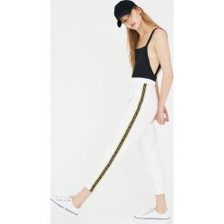 Białe spodnie jogging z lampasami. Białe spodnie damskie Pull&Bear. Za 79,90 zł.