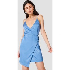 Linn Ahlborg x NA-KD Kopertowa sukienka z satyny - Blue. Niebieskie sukienki damskie Linn Ahlborg x NA-KD, bez wzorów, z satyny, bez kołnierzyka, bez rękawów, kopertowe. W wyprzedaży za 66,97 zł.