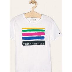 Tommy Hilfiger - T-shirt dziecięcy 128-176 cm. Białe bluzki dziewczęce TOMMY HILFIGER, z nadrukiem, z bawełny, z okrągłym kołnierzem, z krótkim rękawem, krótkie, bez kaptura. Za 149,90 zł.