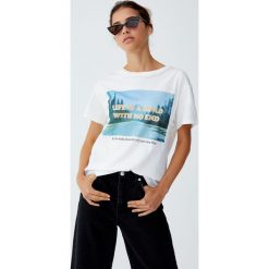 Koszulka z fotograficznym nadrukiem. Białe t-shirty damskie Pull&Bear, m, z nadrukiem, bez kołnierzyka, z krótkim rękawem, krótkie. Za 49,90 zł.