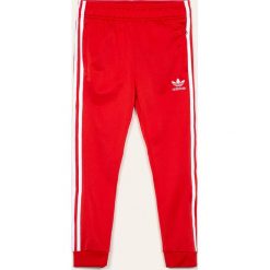 Adidas Originals - Spodnie dziecięce 128-164 cm. Czerwone spodnie chłopięce adidas Originals, bez wzorów, z poliesteru. Za 149,90 zł.