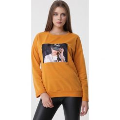 Żółta Bluza Cassia. Żółte bluzy damskie Born2be, s, z nadrukiem, z dzianiny, z długim rękawem, długie, bez kaptura. Za 59,99 zł.