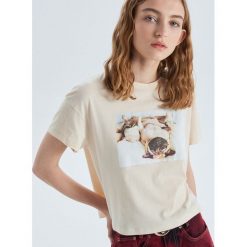 Krótka koszulka oversize z nadrukiem - Kremowy. Białe koszulki damskie marki Cropp, s, z nadrukiem, bez kołnierzyka, z krótkim rękawem. Za 39,99 zł.