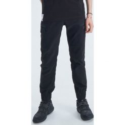 Joggery z kieszeniami kolekcja HAKOBO x Czarny. Czarne spodnie męskie Cropp, s, bez wzorów. Za 119,99 zł.