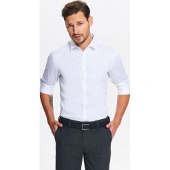 KOSZULA MĘSKA ELEGANCKA Z JEDWABISTYM WYKOŃCZENIEM TKANINY O DOPASOWANYM KROJU. Białe koszule męskie Top Secret, na zimę, m, bez wzorów, z tkaniny, eleganckie, z klasycznym kołnierzykiem, bez rękawów. W wyprzedaży za 39,99 zł.