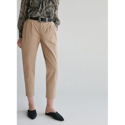 Spodnie chino - Beżowy. Brązowe spodnie damskie Reserved, bez wzorów. W wyprzedaży za 49,99 zł.