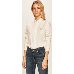Tommy Hilfiger - Koszula. Białe bluzki damskie TOMMY HILFIGER, na co dzień, bez wzorów, z bawełny, klasyczne, z klasycznym kołnierzykiem, z długim rękawem. W wyprzedaży za 319,90 zł.