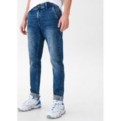 Jeansowe spodnie chino - Niebieski. Niebieskie spodnie męskie marki House, m, bez wzorów, z jeansu. Za 139,99 zł.