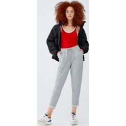 Spodnie jogger z wywiniętymi nogawkami. Szare spodnie damskie Pull&Bear, z dzianiny. Za 49,90 zł.