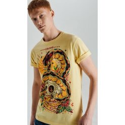 Koszulka z grafiką by Guacala kolekcja Tattoo - Pomarańczowy. Pomarańczowe koszulki męskie Cropp, s, bez wzorów, bez kołnierzyka, bez rękawów. W wyprzedaży za 19,99 zł.