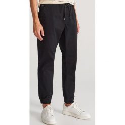 Bawełniane spodnie jogger - Czarny. Czarne spodnie męskie Reserved, m, bez wzorów, z bawełny. Za 129,99 zł.