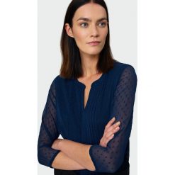 Elegancka bluzka z tkaniny plumeti. Bluzki damskie Greenpoint, bez wzorów, z poliesteru, eleganckie, bez kołnierzyka, bez rękawów. Za 99,99 zł.