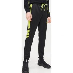 Joggery z nadrukiem - Czarny. Czarne spodnie męskie Cropp, s, z nadrukiem. Za 99,99 zł.